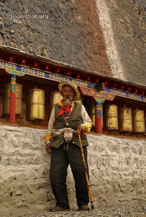 Tibet, Sakya, old man in frond of monastery in mountain